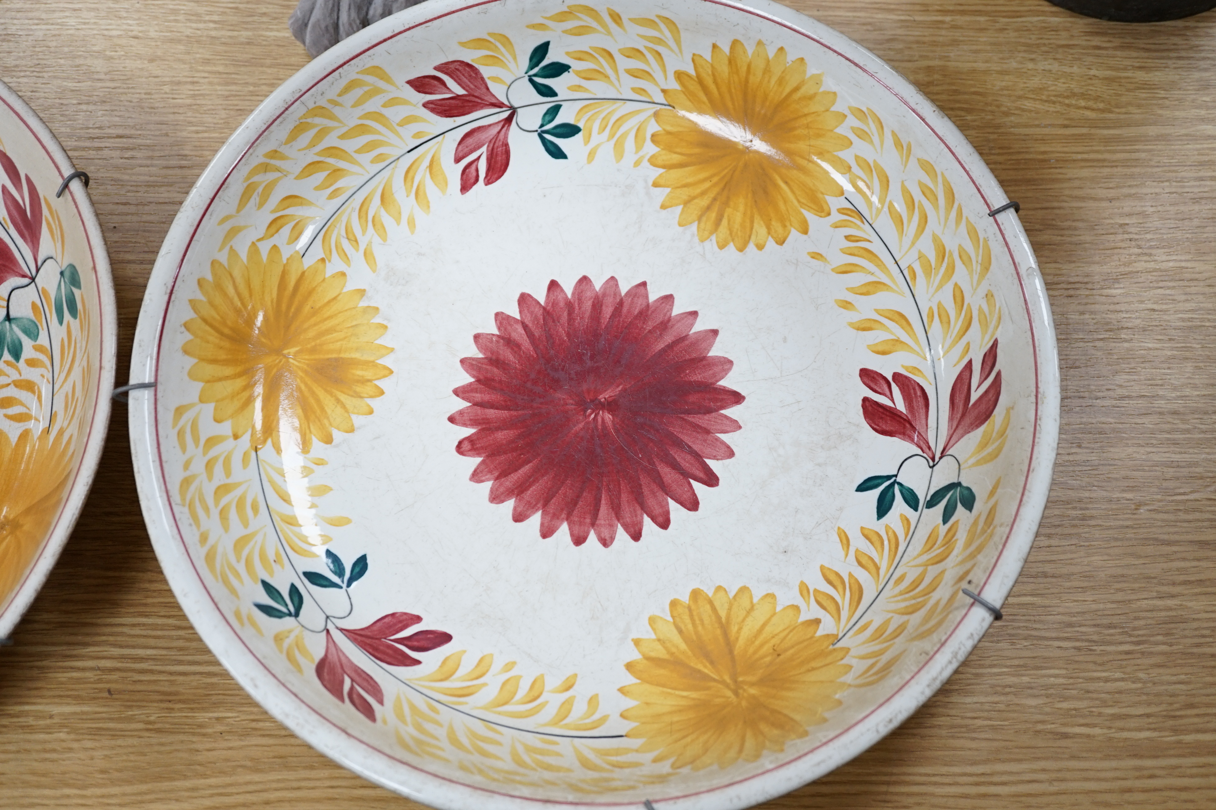 A George Jones & Sons crescent pottery floral wall plate and a similar Staffordshire example, 37cm in diameter